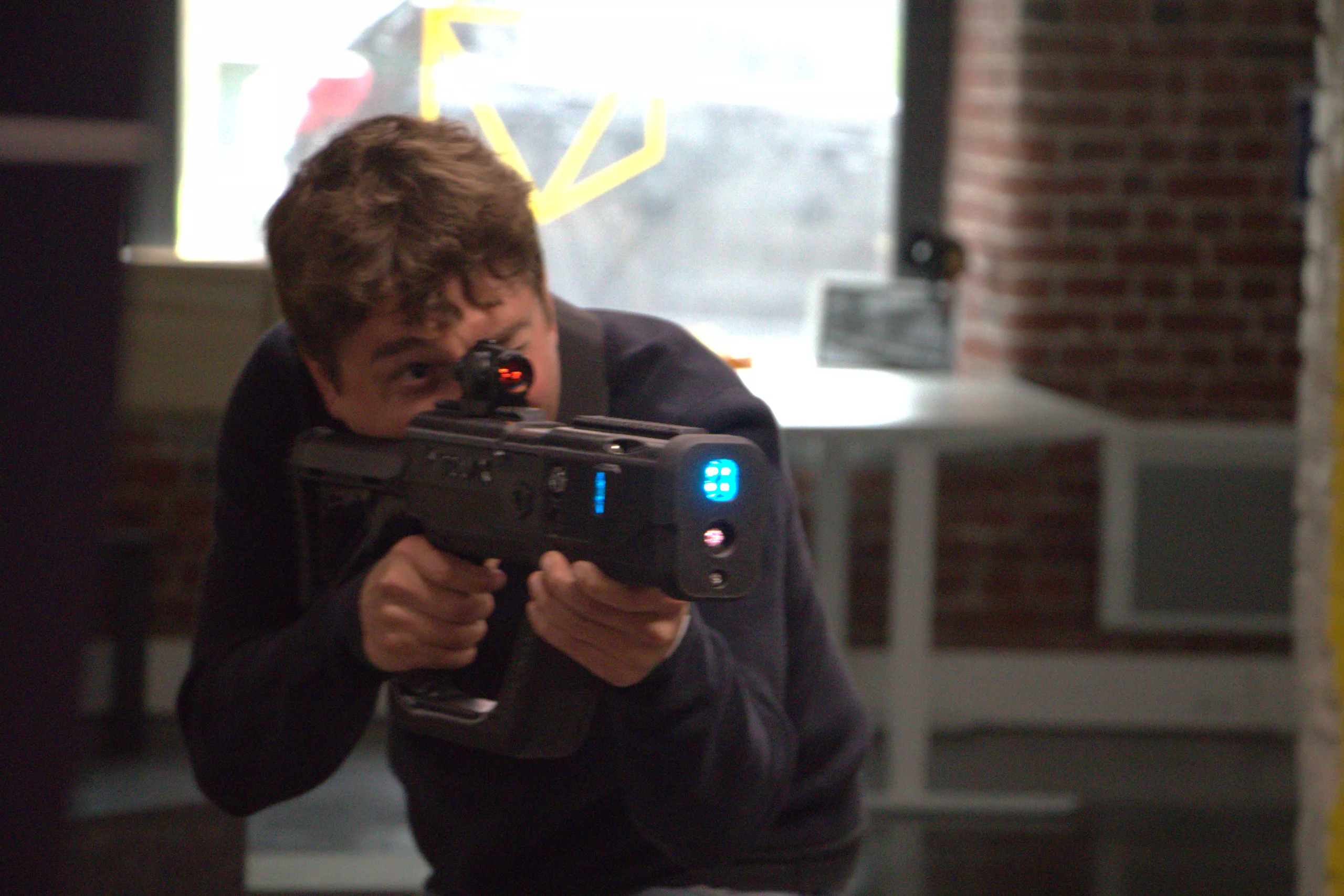 Joueur de laser tag indoor visant avec un blaster BRAVIX PRO
